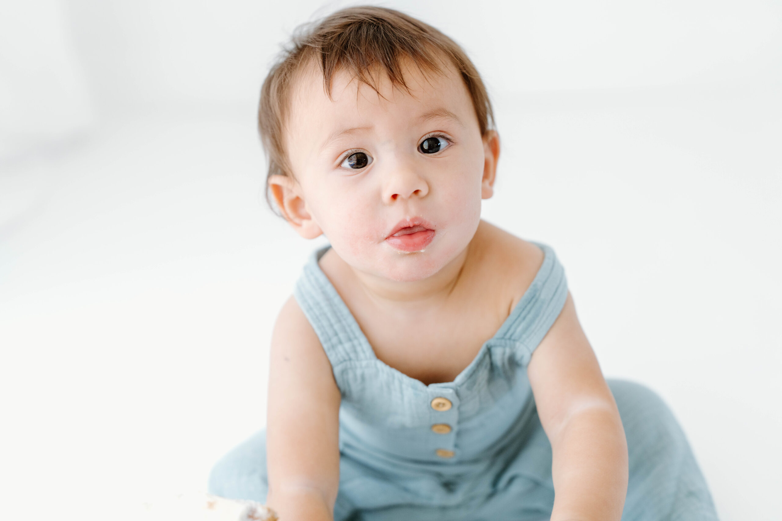 Close-up of Zachary looking curious in his blue romper