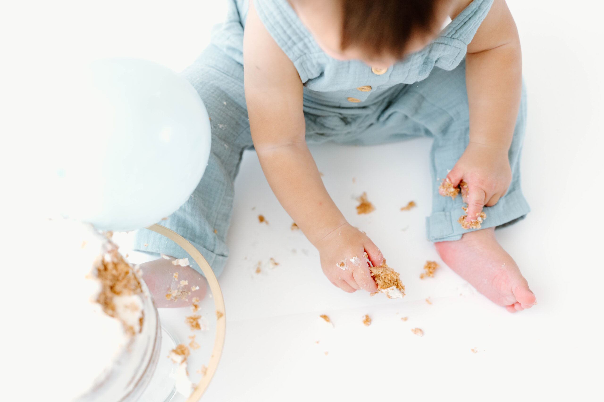 Close-up of cake crumbs on the floor around Zachary's feet