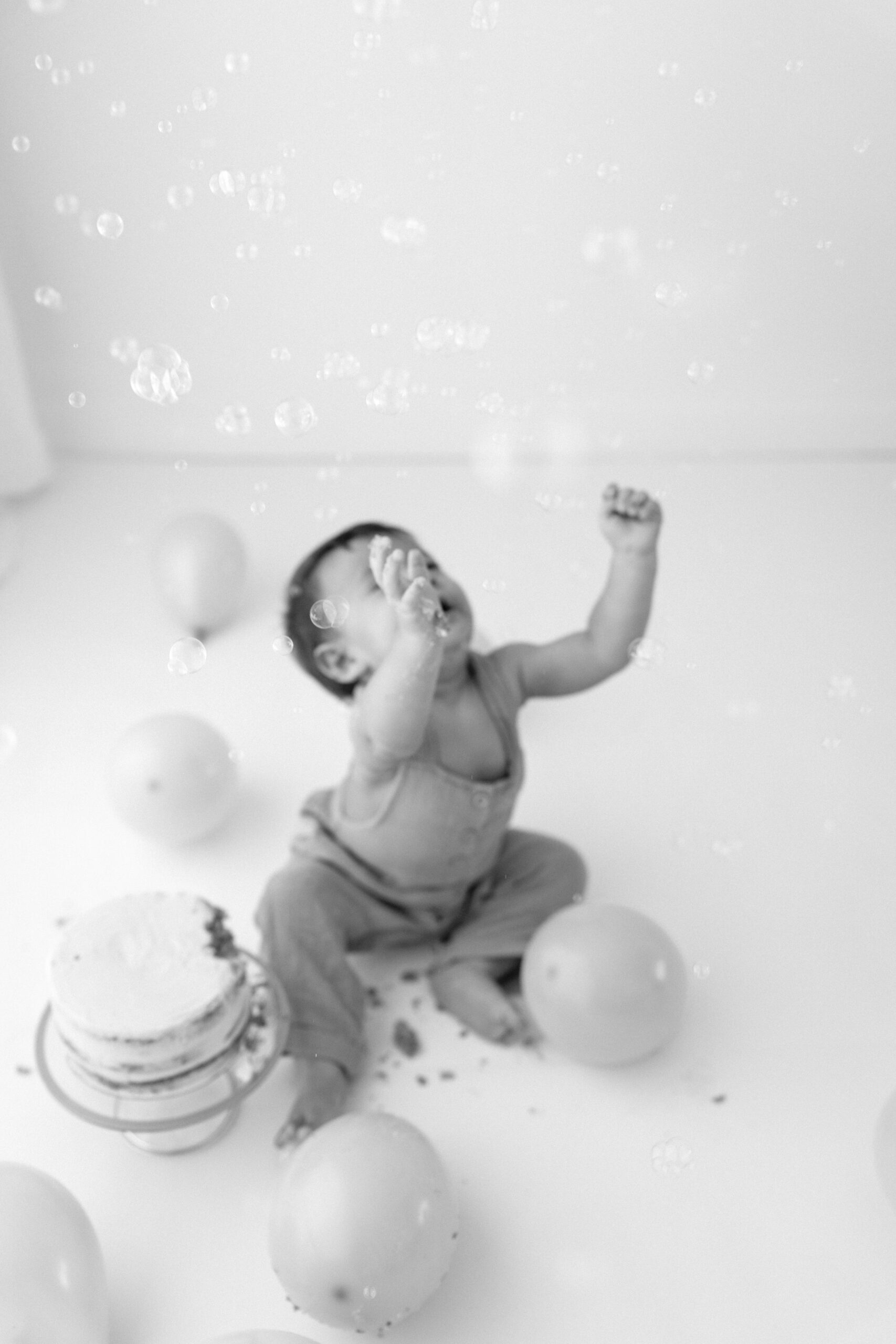 Black-and-white photo of Zachary reaching for floating bubbles