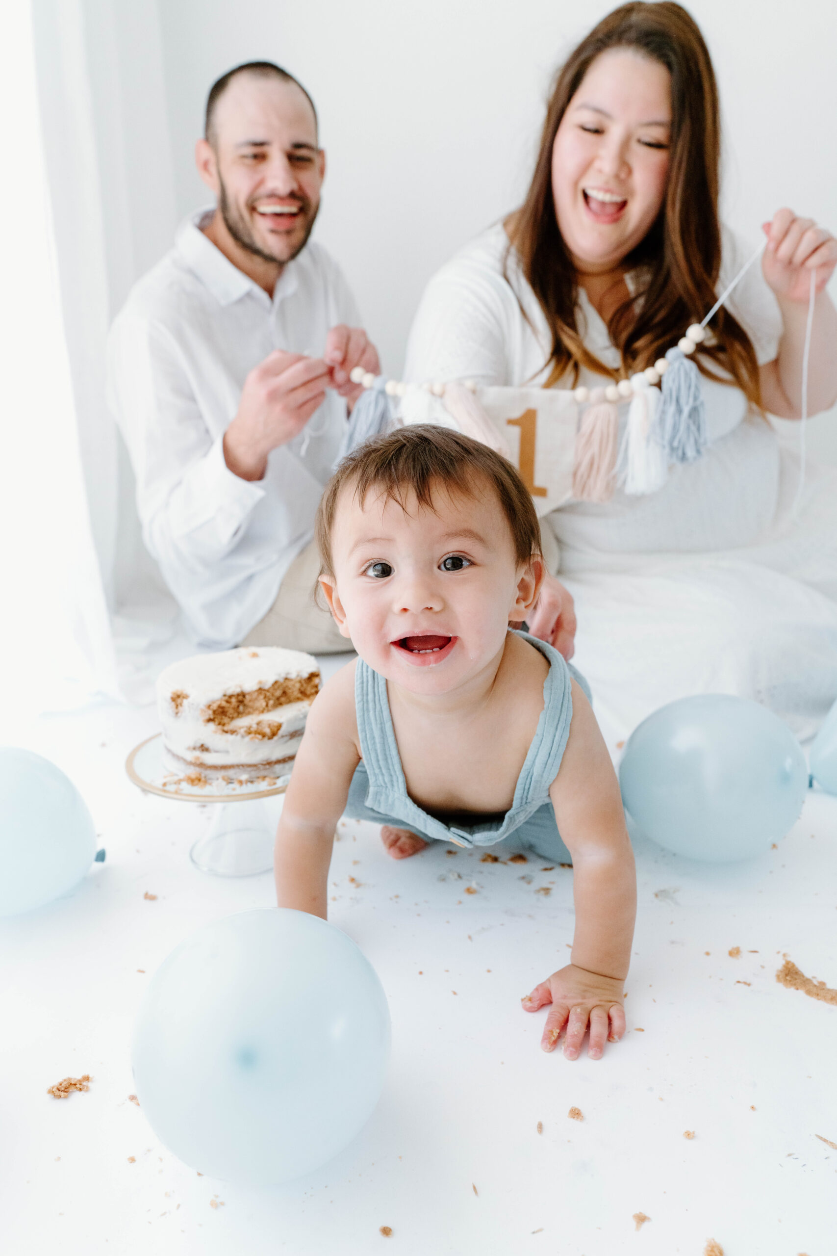 Zachary crawls toward the camera as his parents laugh