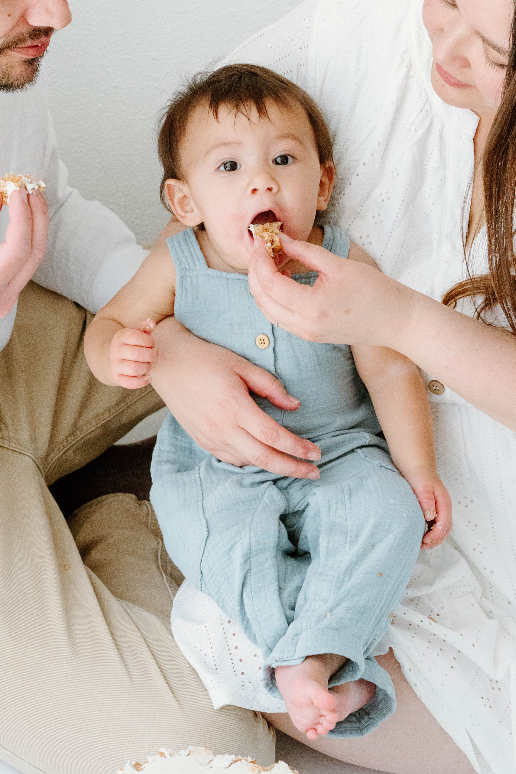 Zachary eats cake from his mom's hand