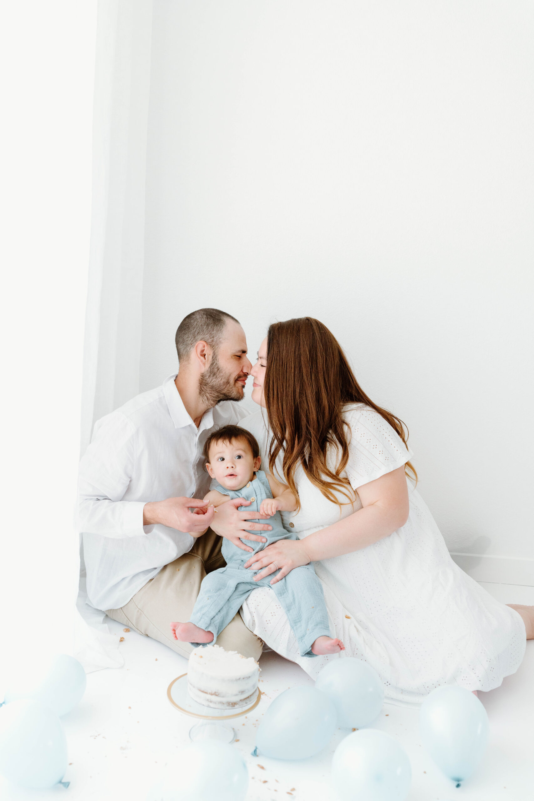 Mom and dad kiss as Zachary sits in their laps