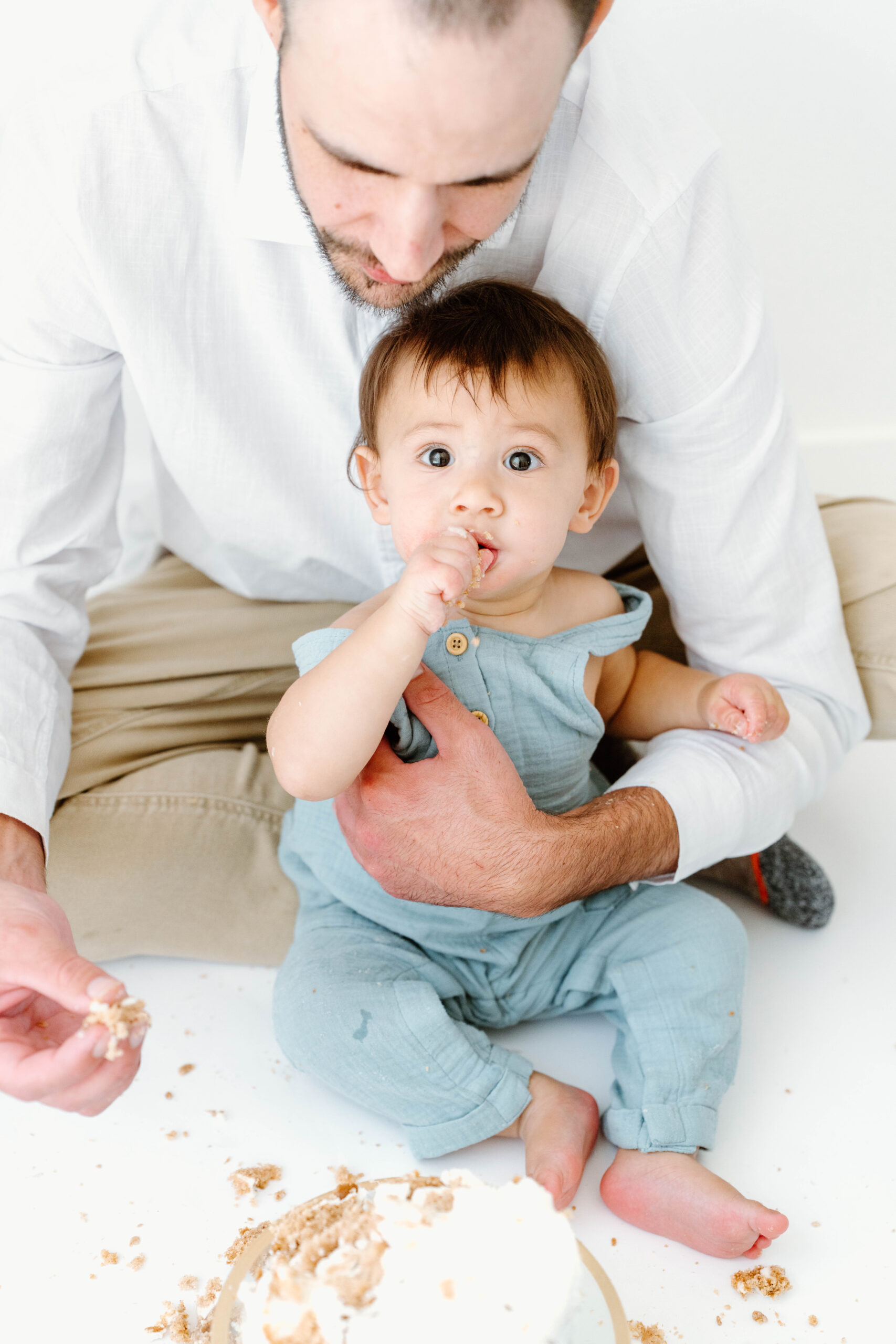 Zachary eats cake on his dad's lap