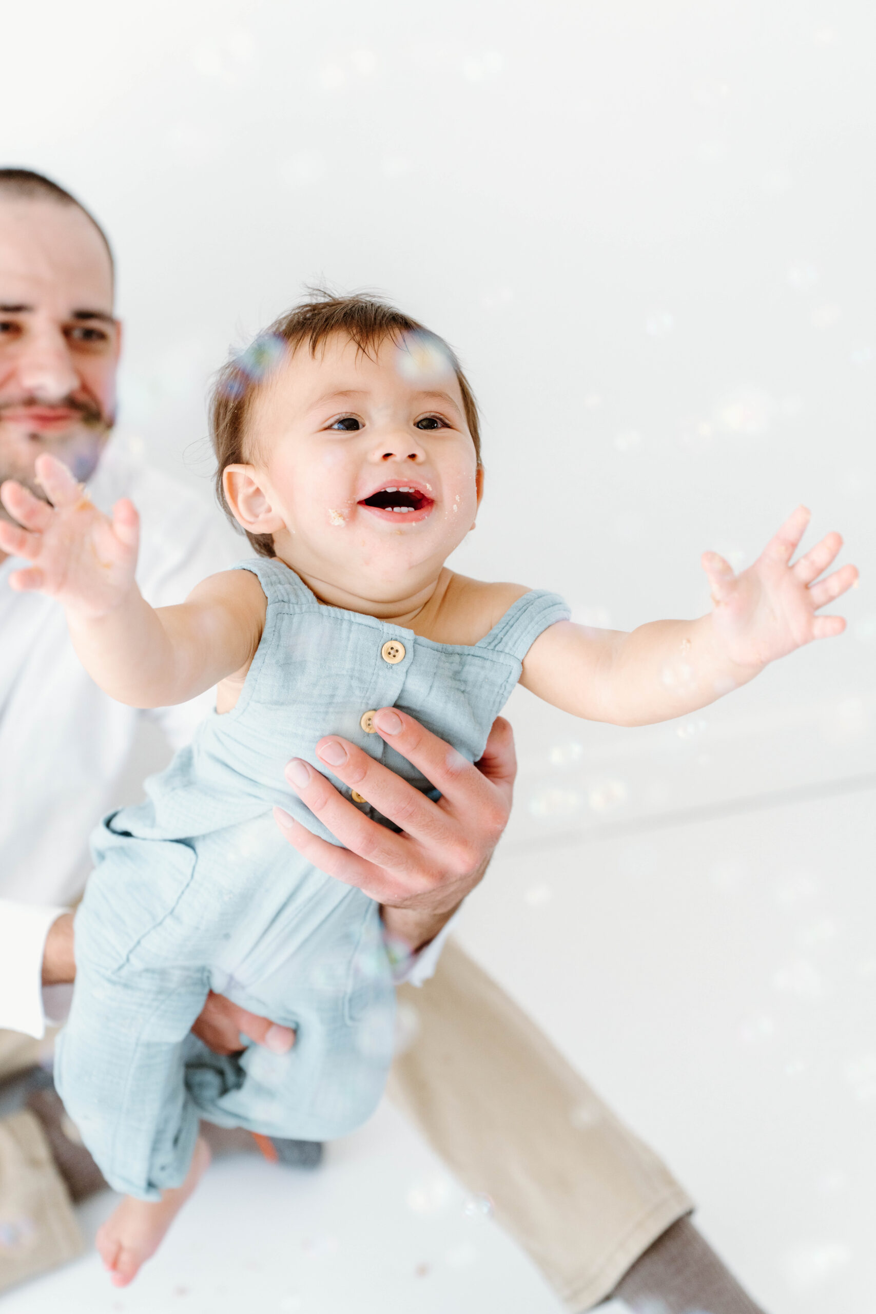 Zachary laughs at the bubbles in his dad's arms