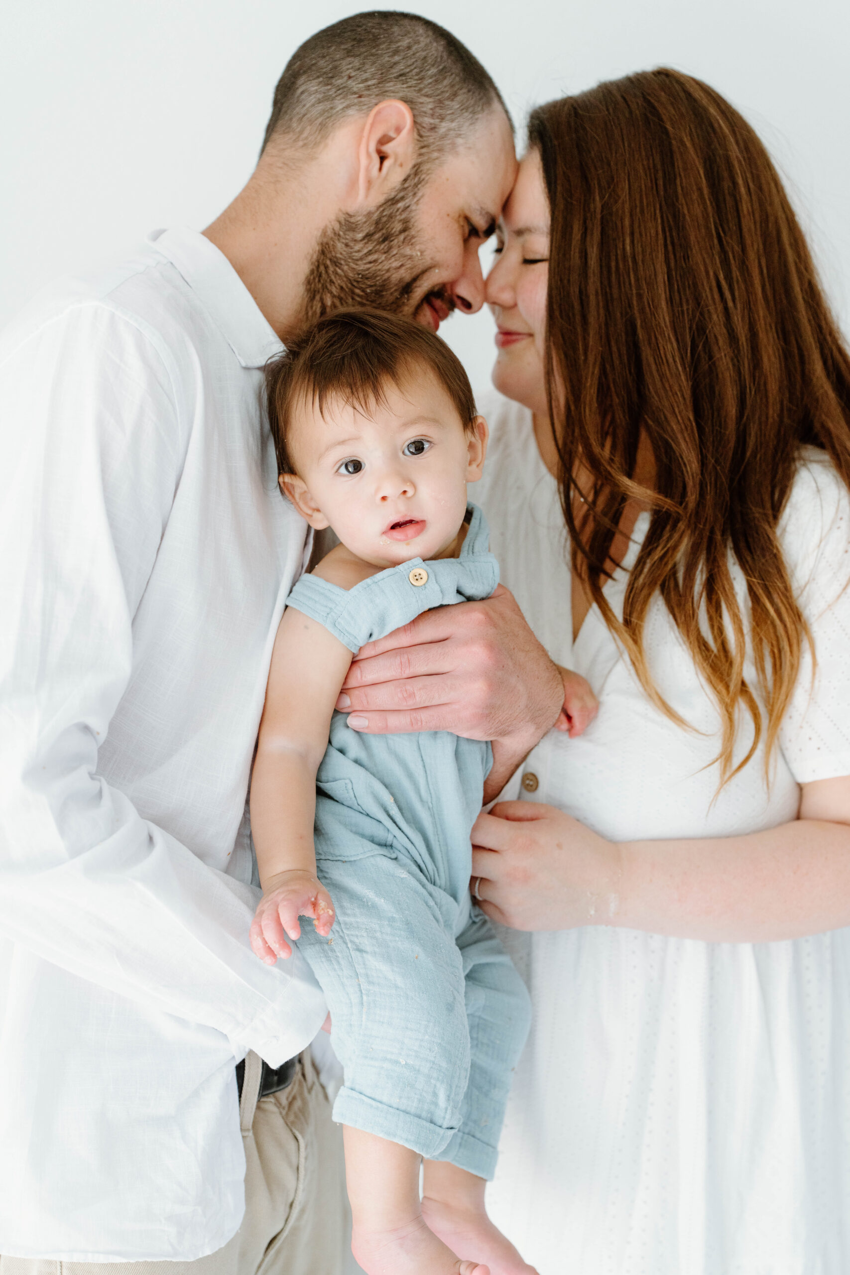 Zachary's parents touch foreheads as they hold him