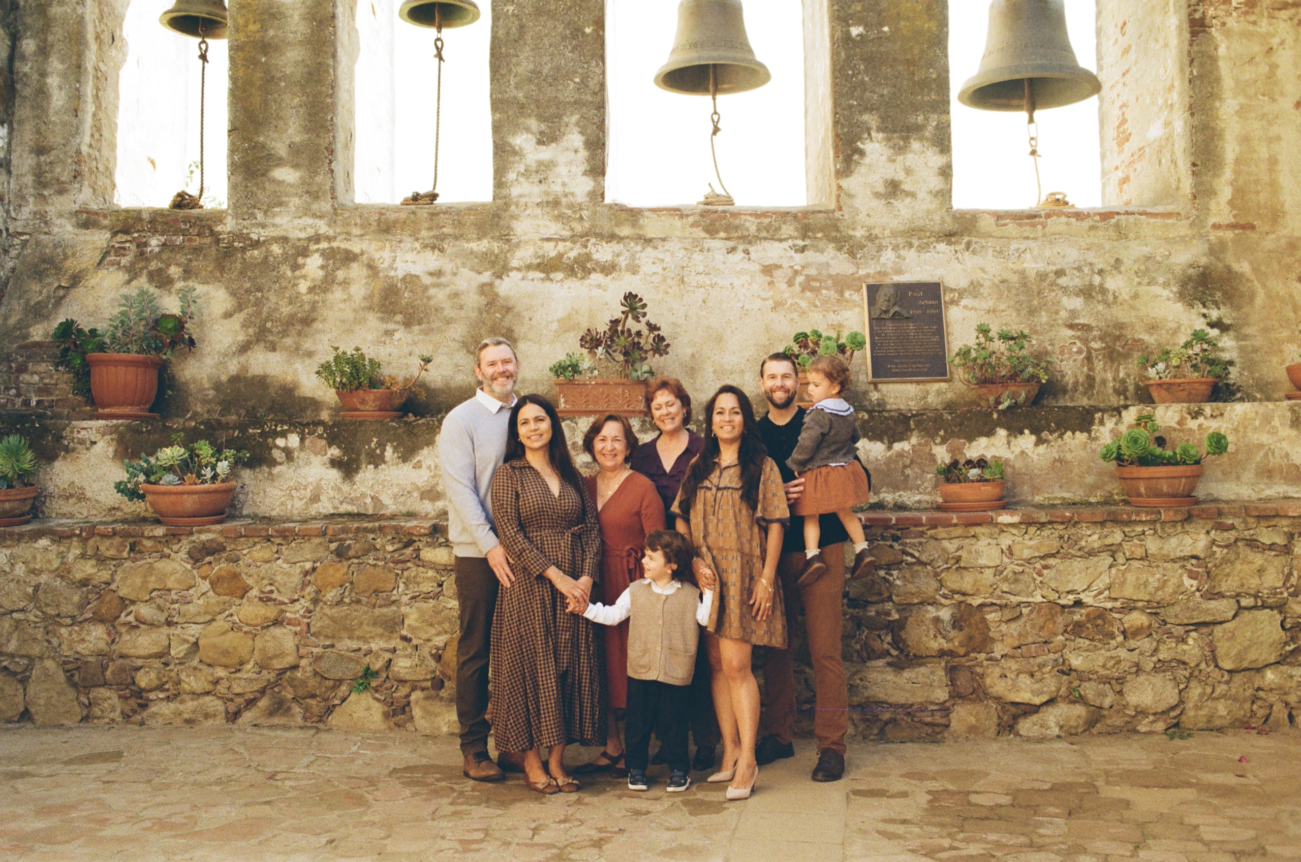Film photo of the extended family in front of the Mission bell wall