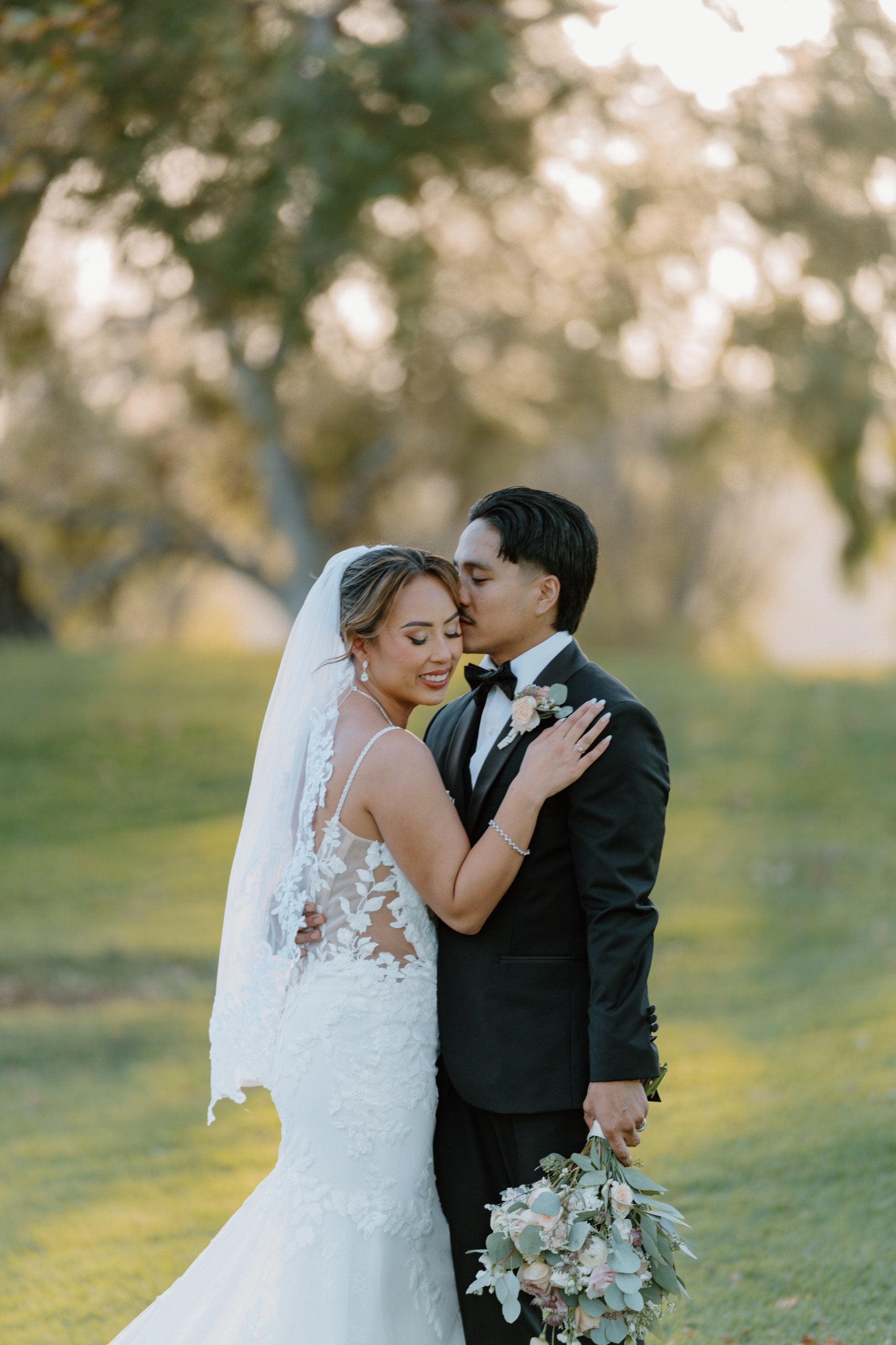 Bride and groom in golden hour light on the lawn at Mountain Meadows Golf Course