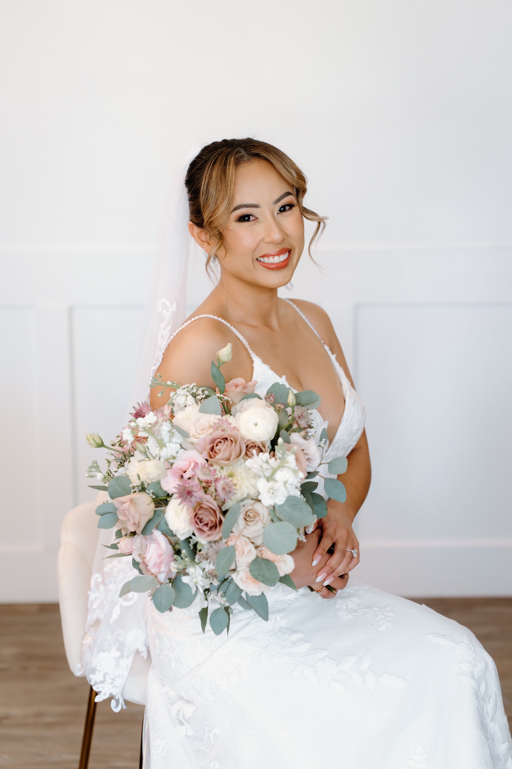 Jane smiling with her blush and white bouquet before the ceremony