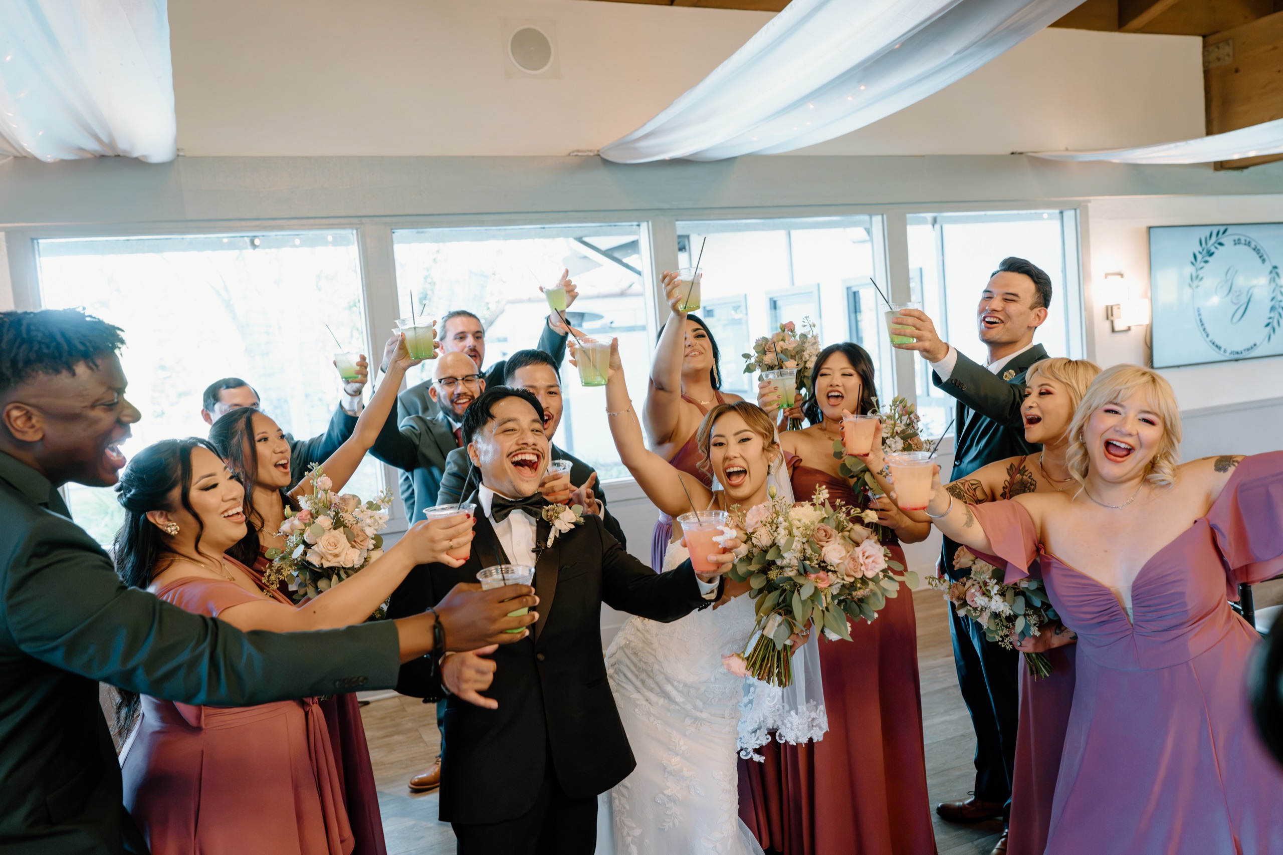 Jane and Jon’s wedding party cheering with raised bouquets